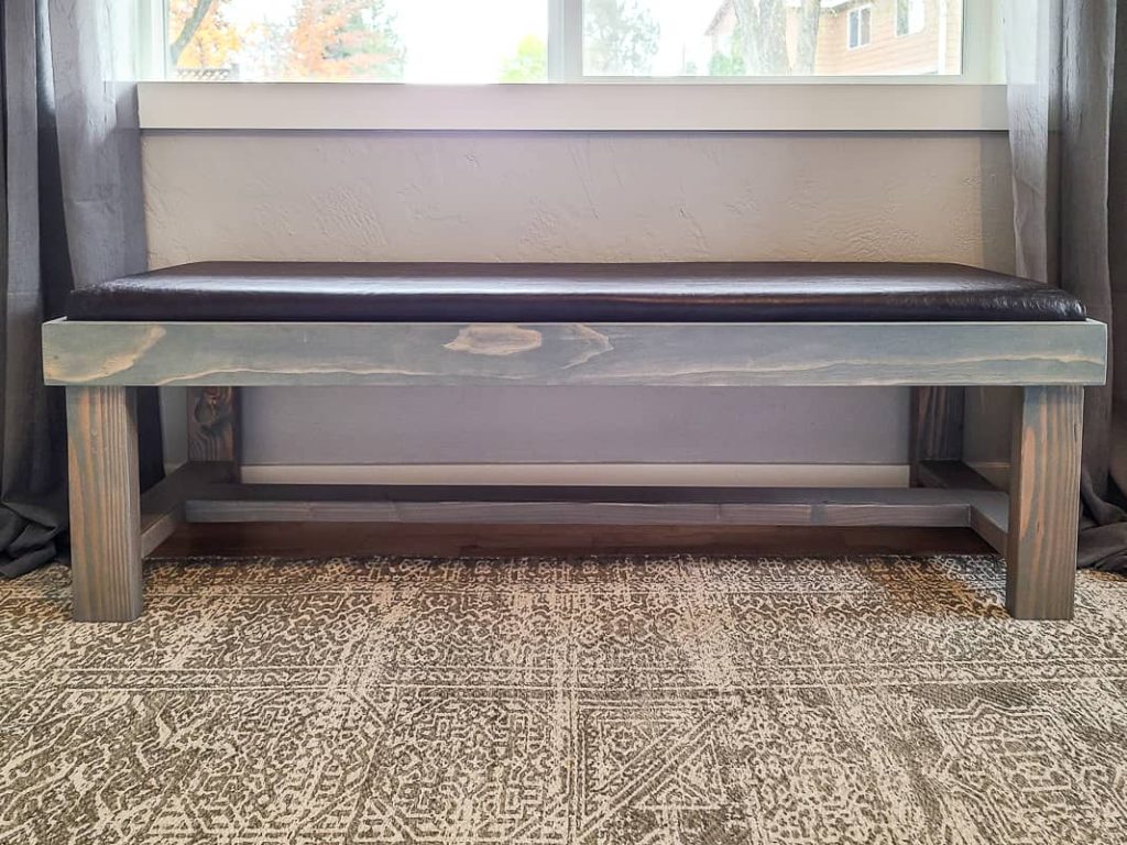 Image of completed DIY bench cushion on bench in front of window.