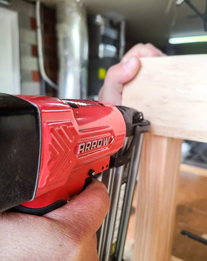 Attaching trim pieces to DIY bench using an Arrow pneumatic brad nail gun.