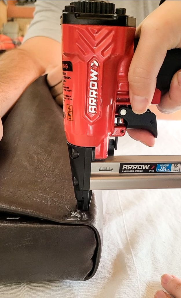 Close up image of attaching leather material using an Arrow staple gun.