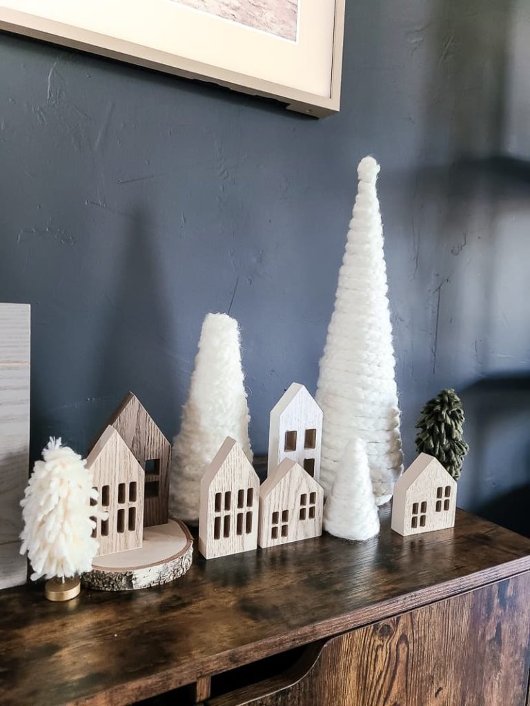 Side view of the Christmas village with boho DIY yarn Christmas trees and mini wooden houses