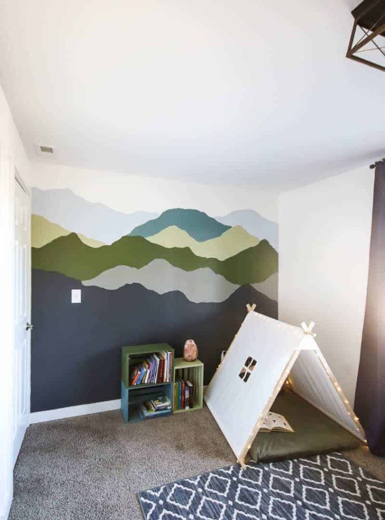 mountain mural painted with blue and green colors in a little kid's room with tent reading corner
