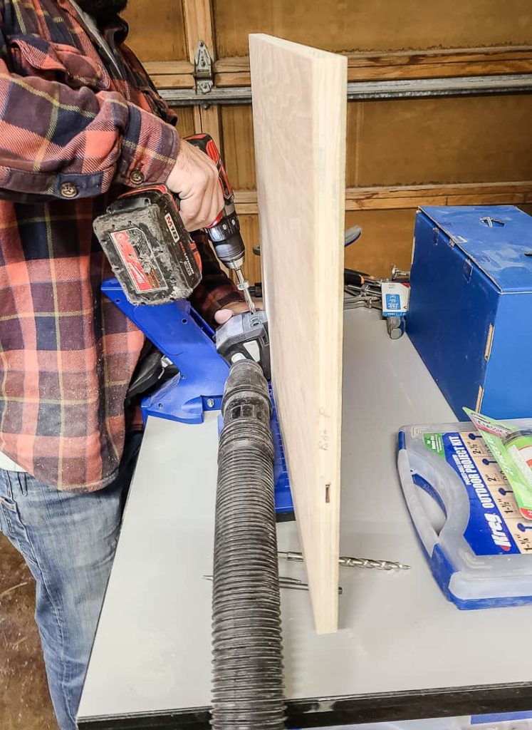 A man is drilling the pocket hole for a bedside table