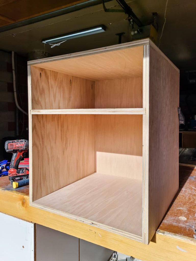 A photo showing the assembly of the nightstand's shelf.
