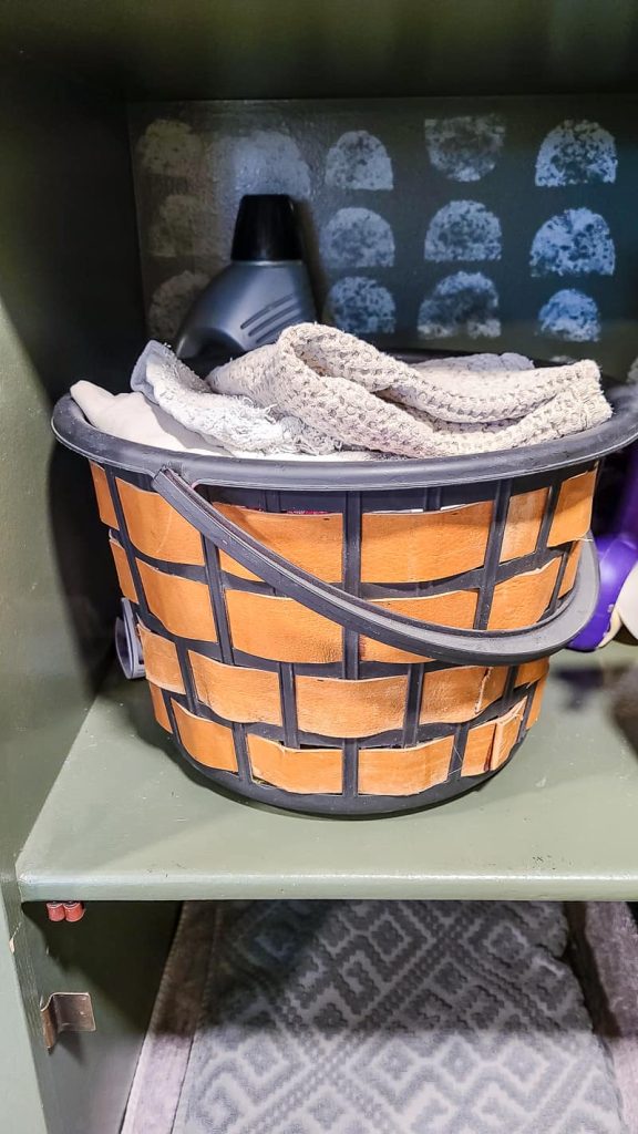 Cleaning rags organized in a basket on a shelf.