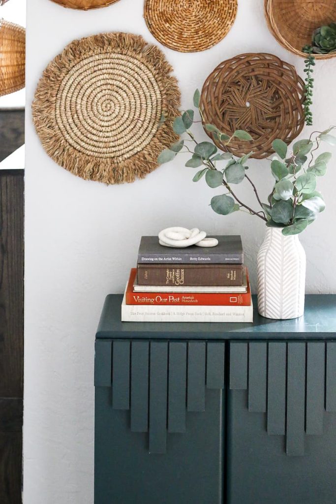 In our hallway, we have this small table with vase, books, decorative clay knot, and rattan baskets