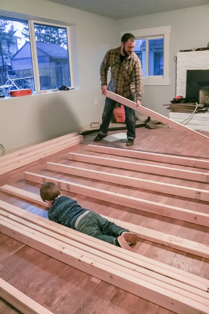 Man laying out 2x4s for a wall.