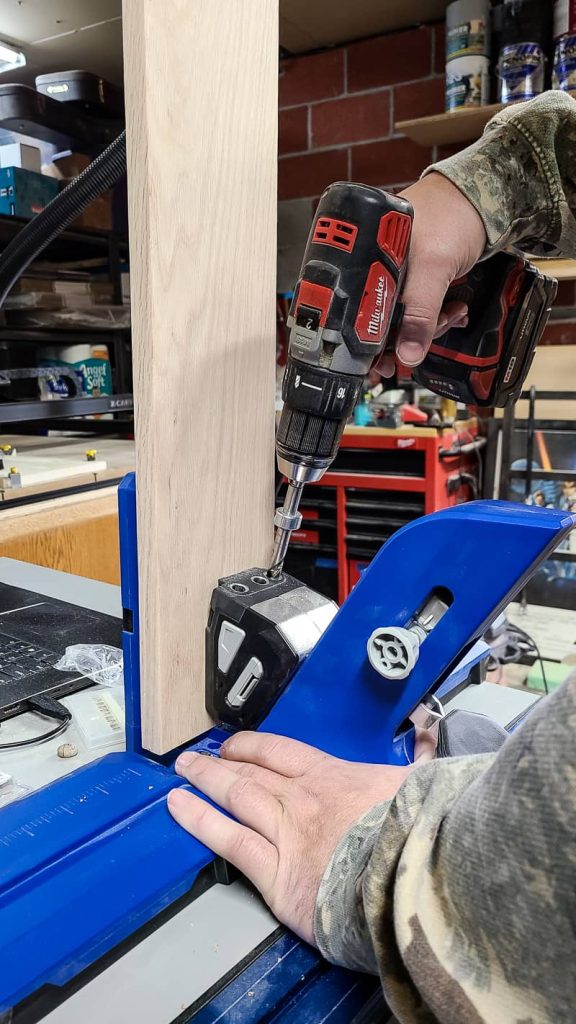 Man using drill to make pocket holes in a board using a Kreg720 Pro pocket hole jig.