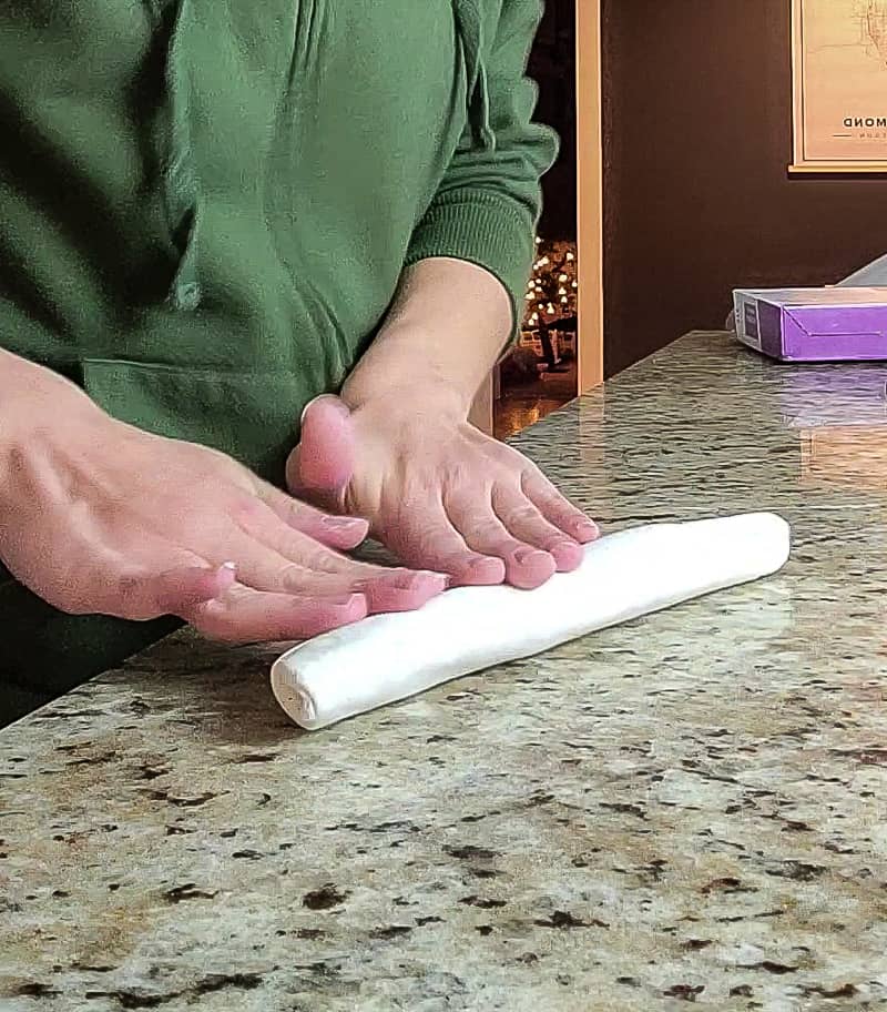 Once the polymer clay is pliable, you can roll clay into a snake shape before looping into a knot shape. 