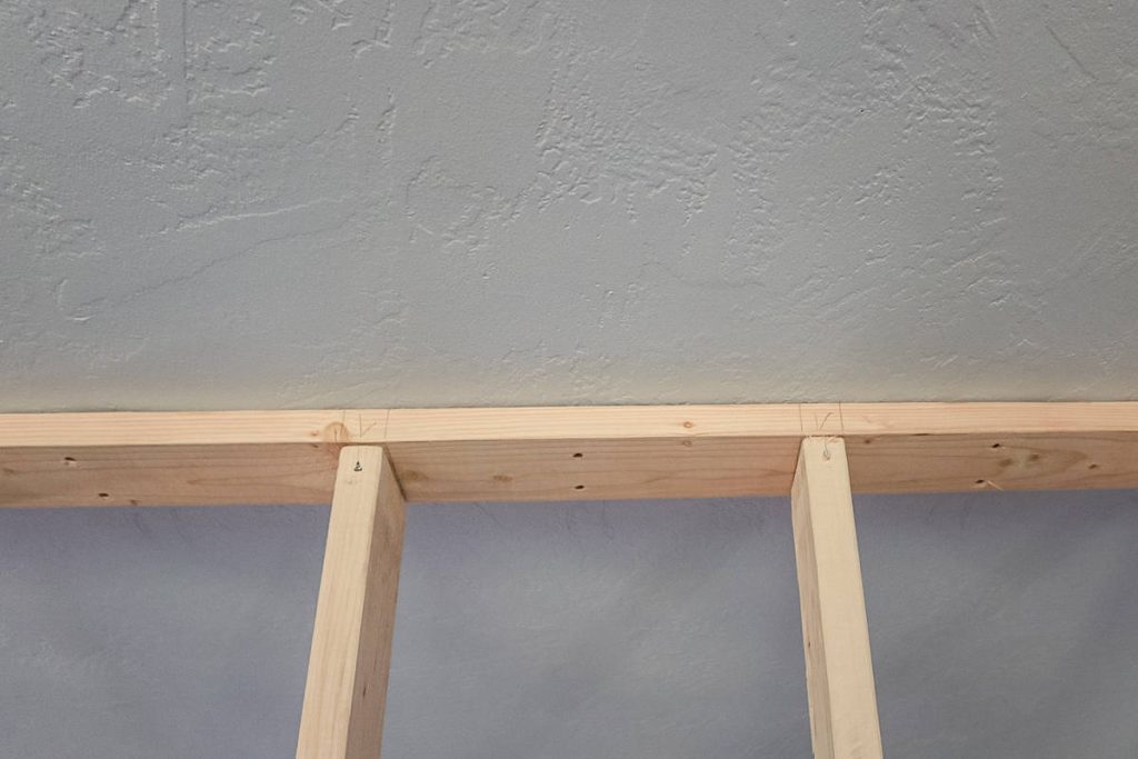 2x4s attached to make a wall where marks were drawn for stud spacing.