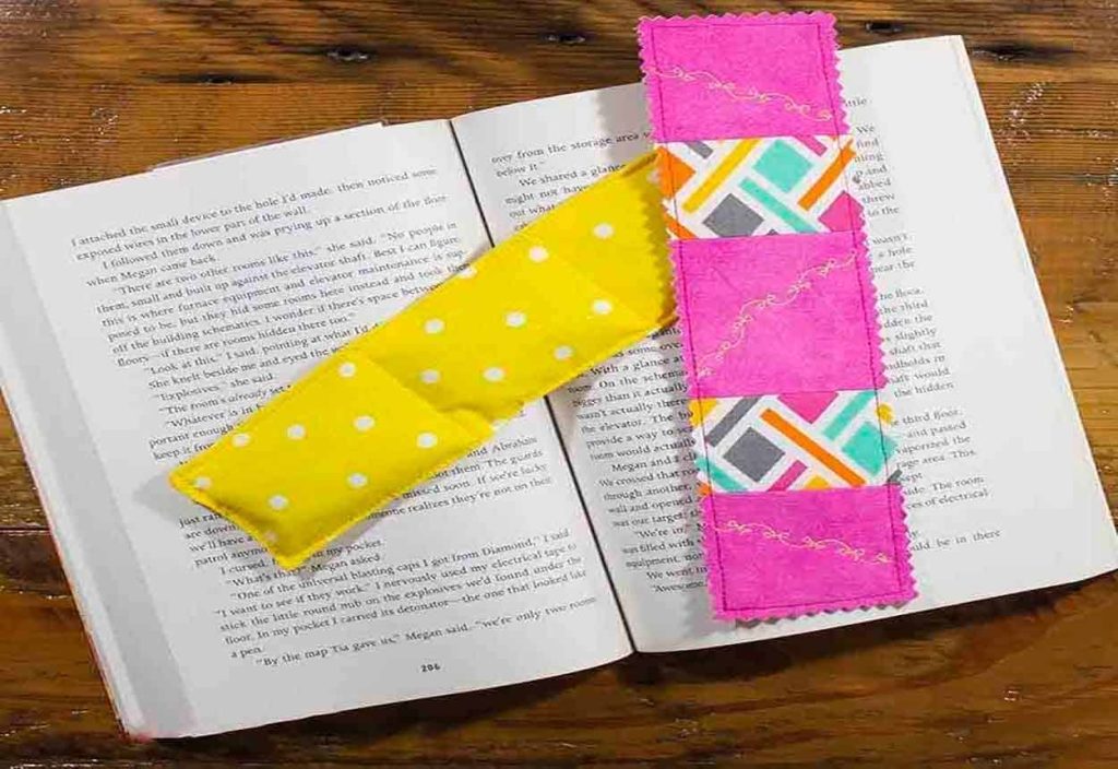 Yellow and pink fabric bookmarks laying on an open book