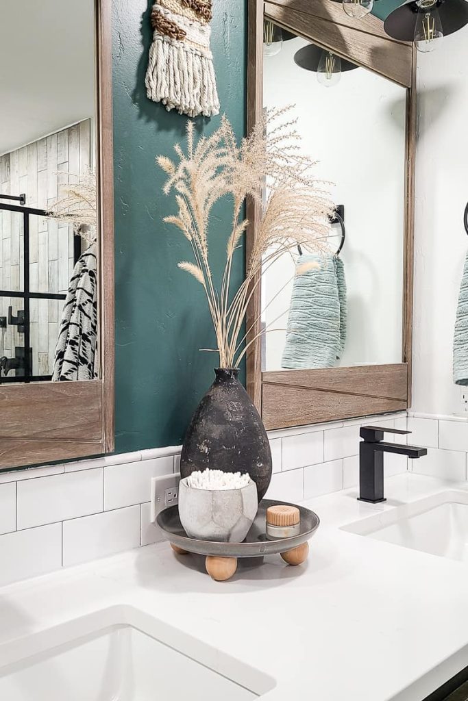 Closeup of DIY footed tray on bathroom vanity counter with potter vase and wheat stalks, bowl with Q-tips and small jar of eye cream