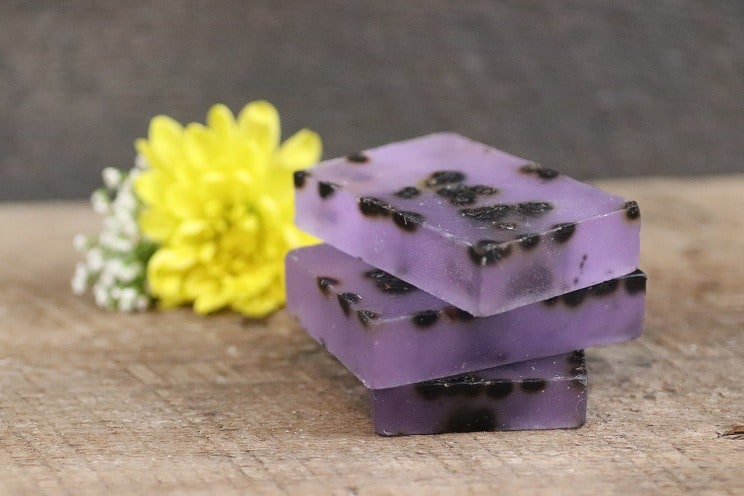 three bars of purple soap with dried elderberries