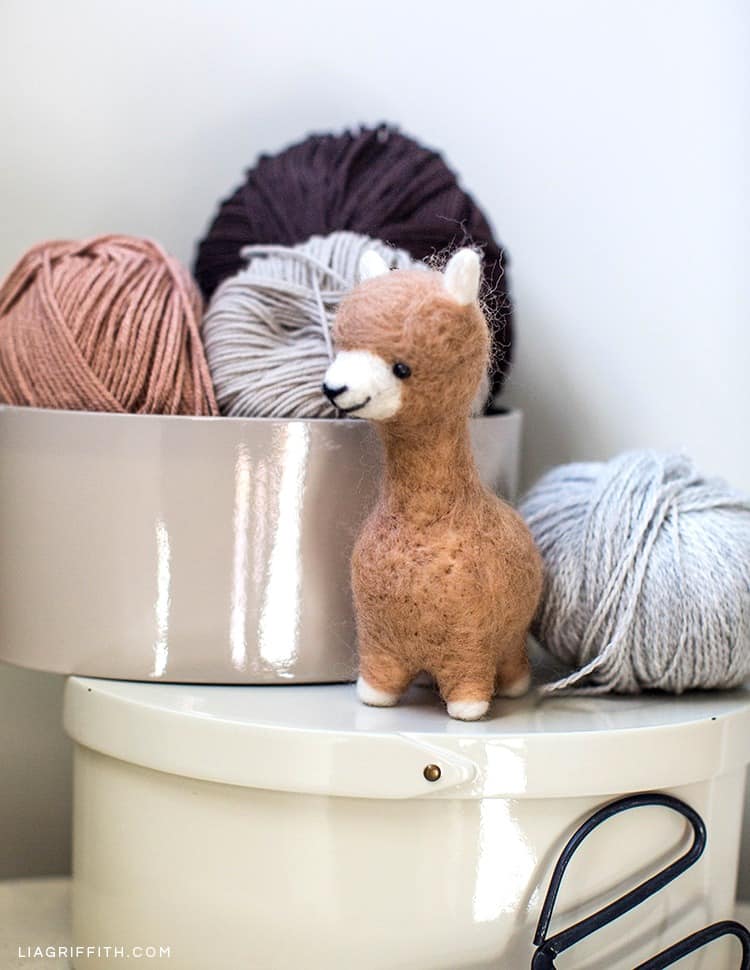 felted alpaca sitting on box of yarn