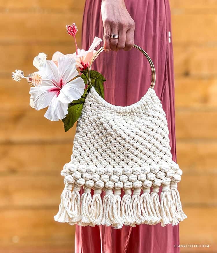 lady in pink dress holding macrame handbag