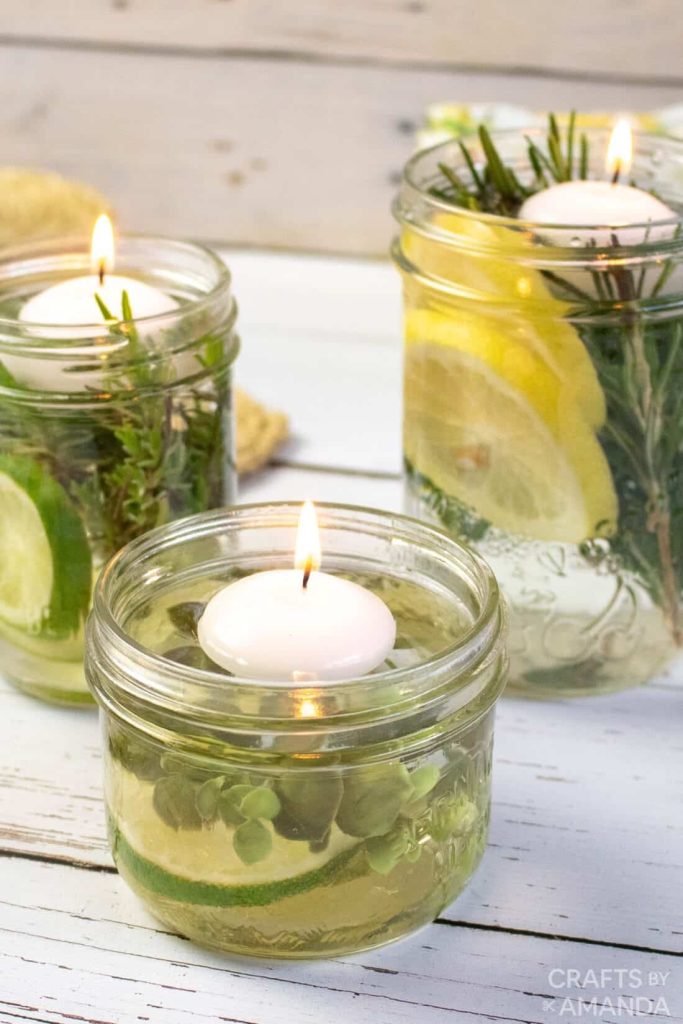 Three jar candles with cucumbers and lemons in the wax.