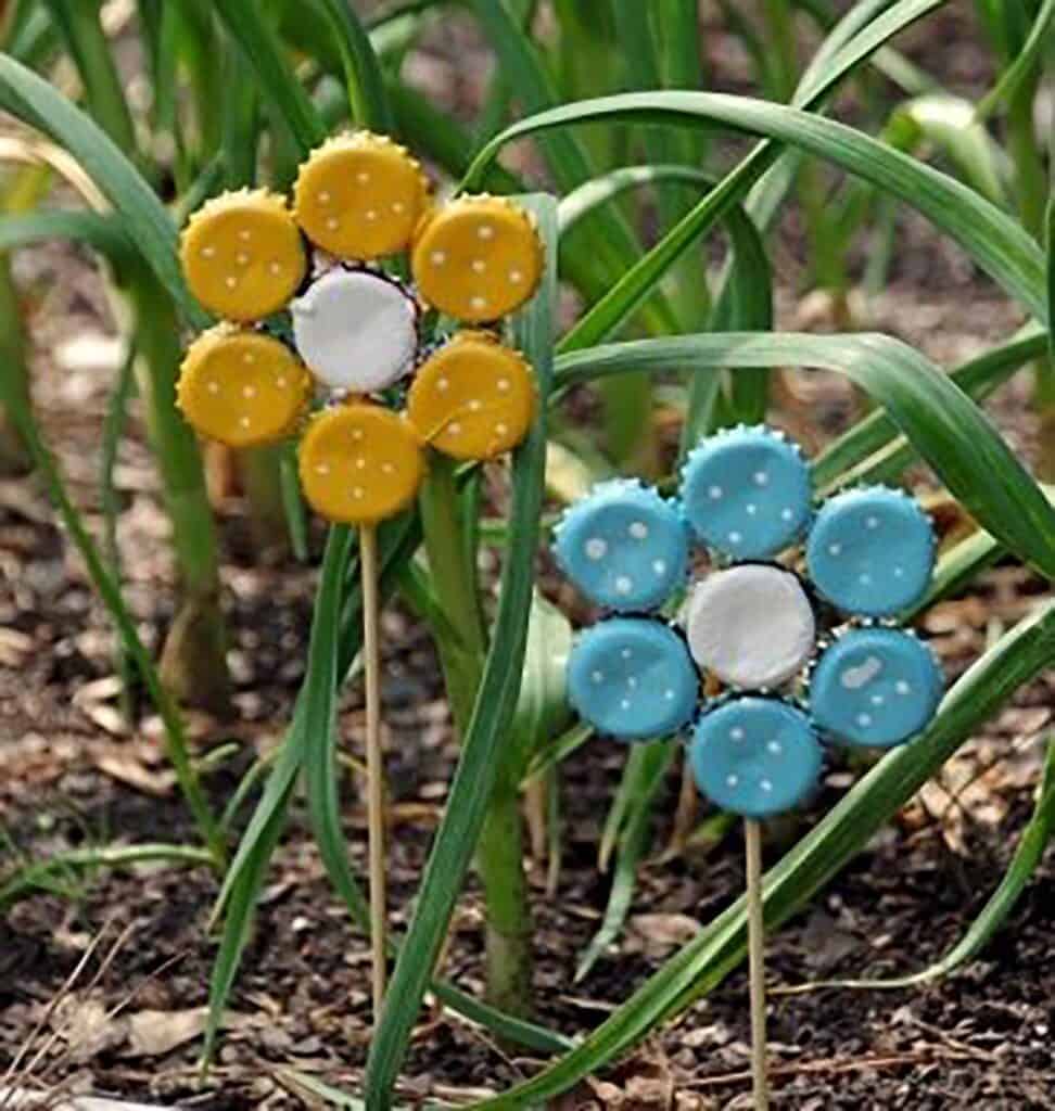 flower shaped garden art in blue and yellow made from bottle caps