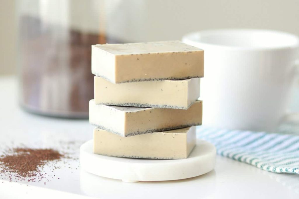 Four bars of melt and pour coffee soap stacked on a white coaster
