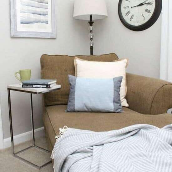 throw pillows on chair with blanket and side table