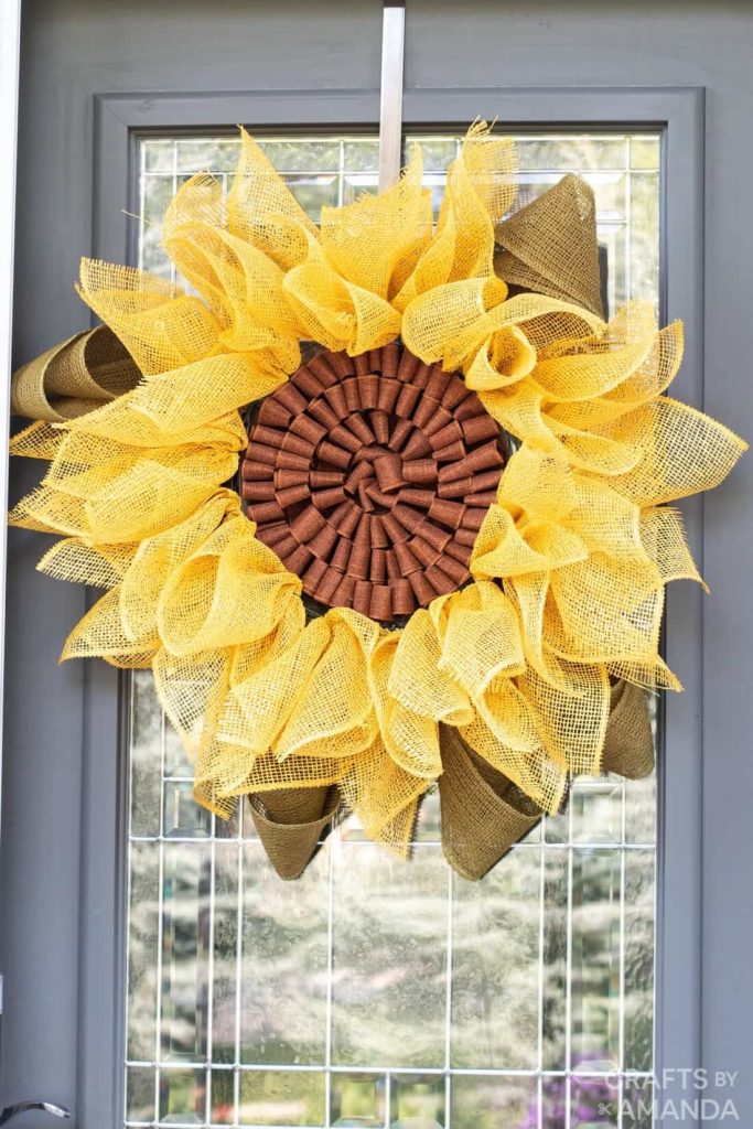 yellow sunflower wreath made with burlap hanging on a door