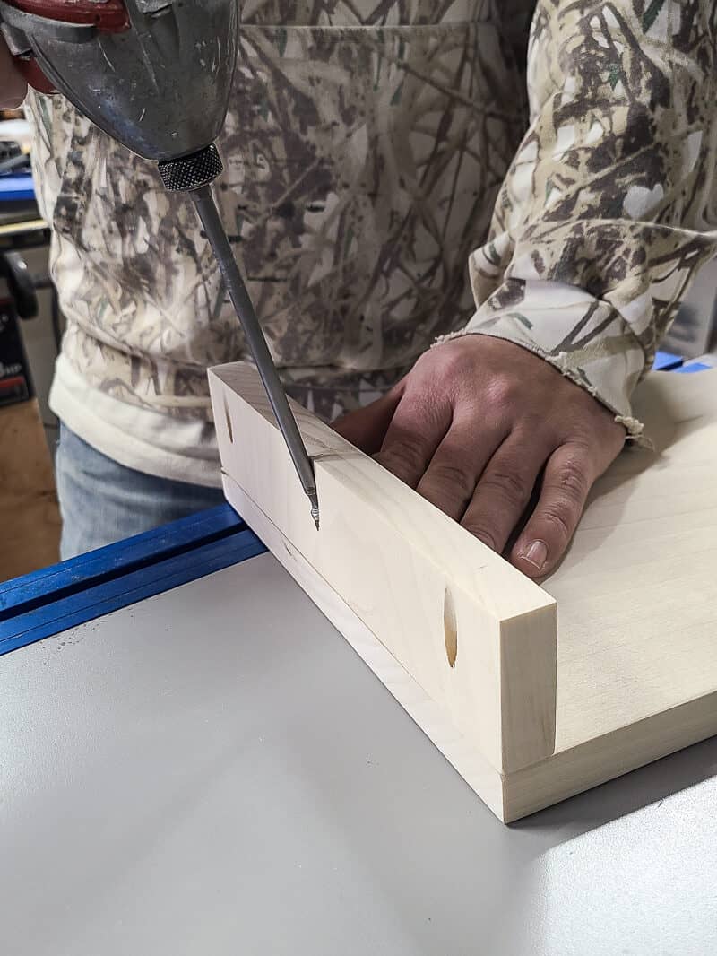 Man attaching bottom of cookbook stand using drill and pocket hole joinery.