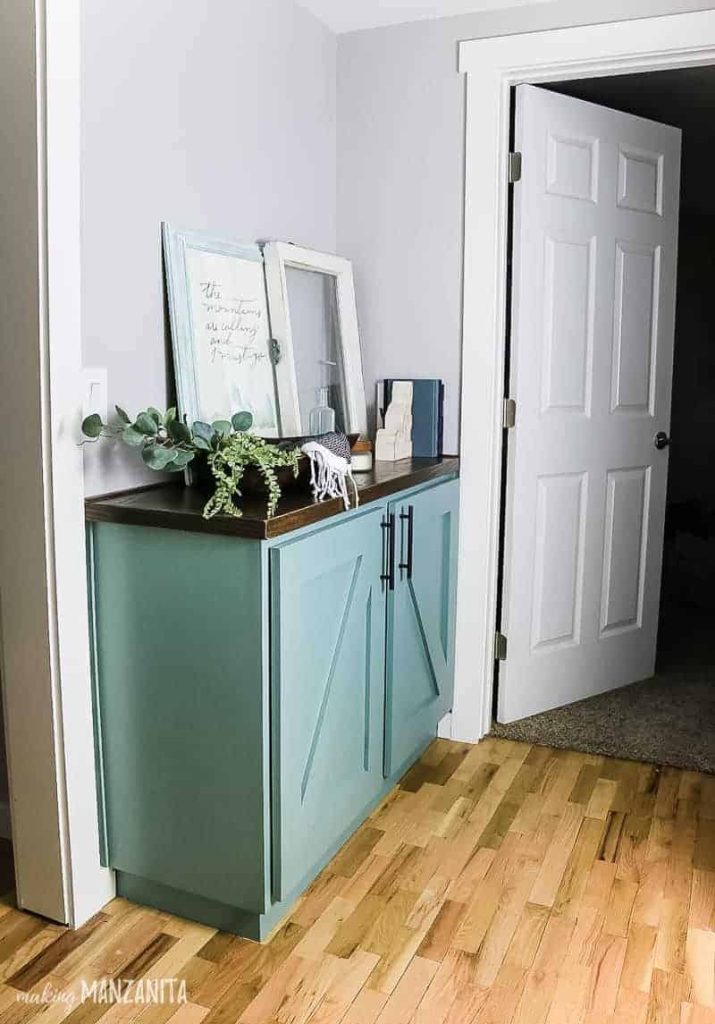 Buffet cabinet painted with In the Moment Behr paint color with wood stained top and black hardware.