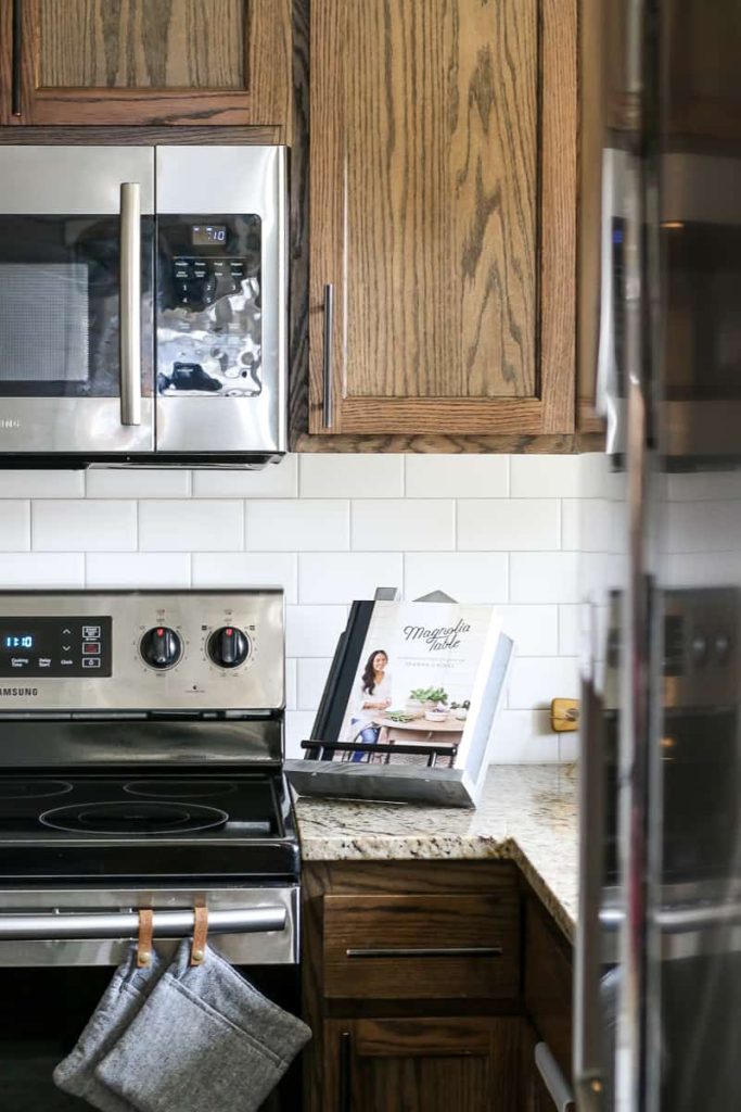 DIY cookbook stand on the kitchen counter next to the stove with the Magnolia Table cookbook sitting in it.