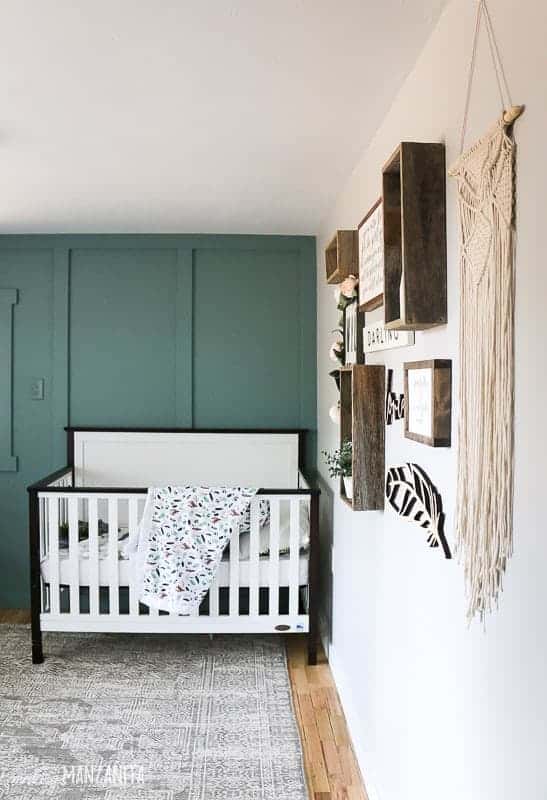 View nursery gallery wall and crib in front of accent wall painted Behr's In the Moment paint color.