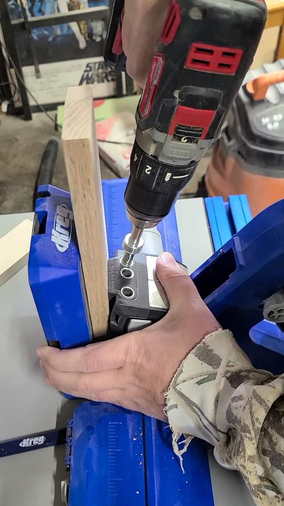 Man making pocket holes in a board using a pocket hole jig.