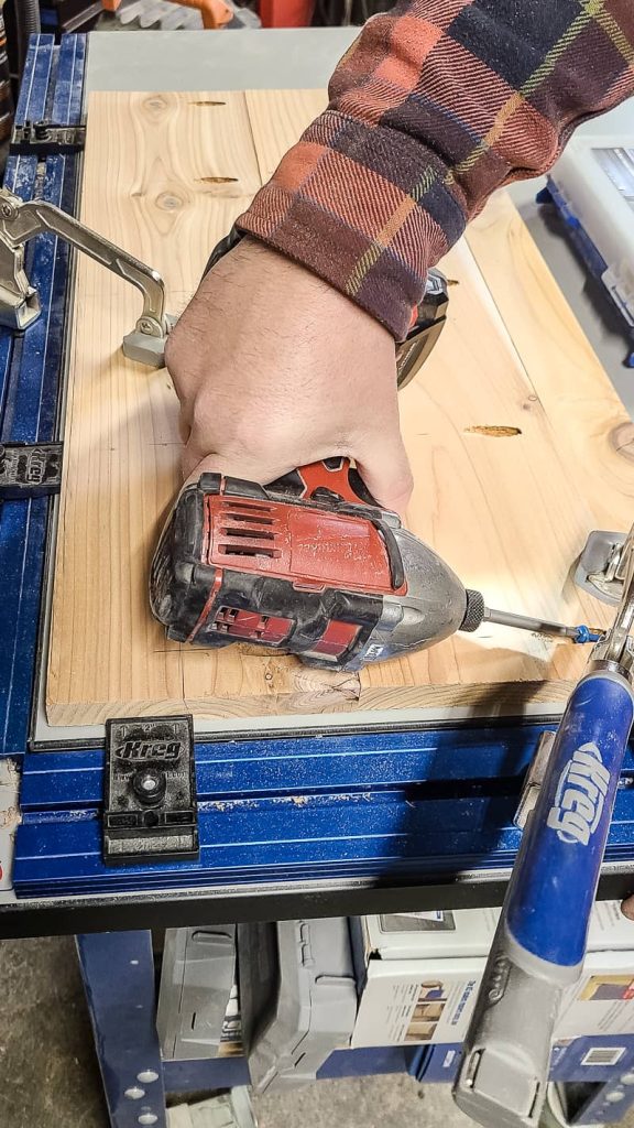 A man uses tools to connect the door slats with pocket holes.