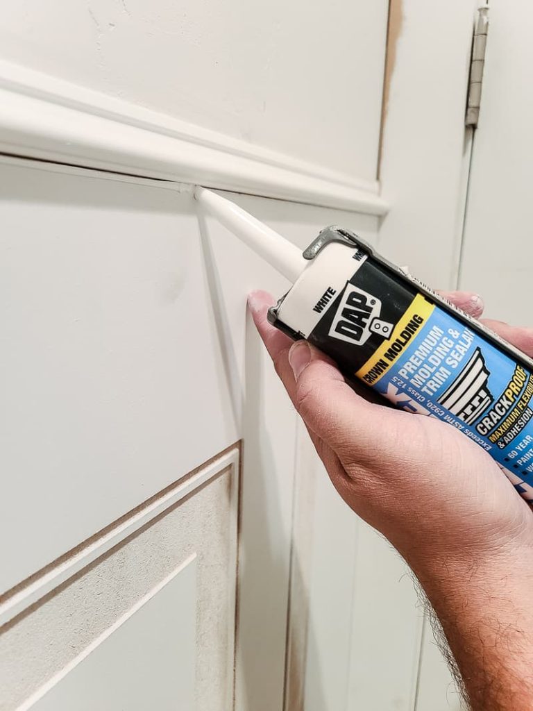 Apply DAP premium molding and trim sealant to the gap between the molding and the wainscoting panel.