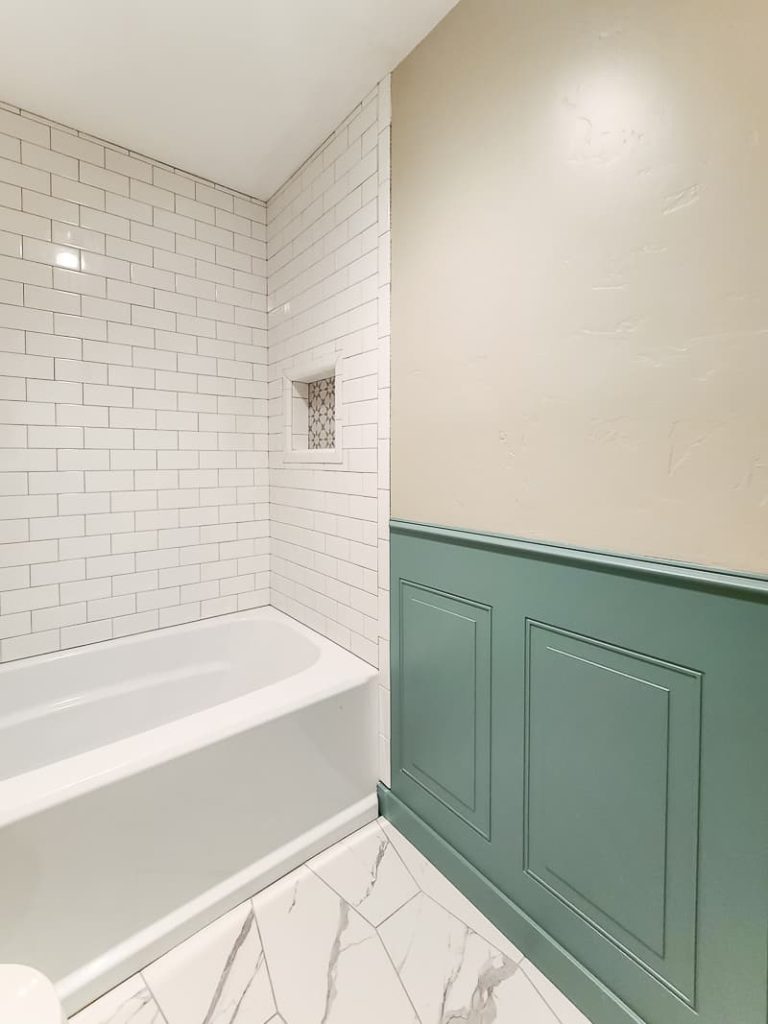 Closeup view of painted wainscoting panel next to the bathtub.