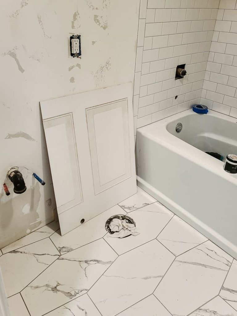 Cut wainscoting panel sitting against the bathroom wall to be installed.