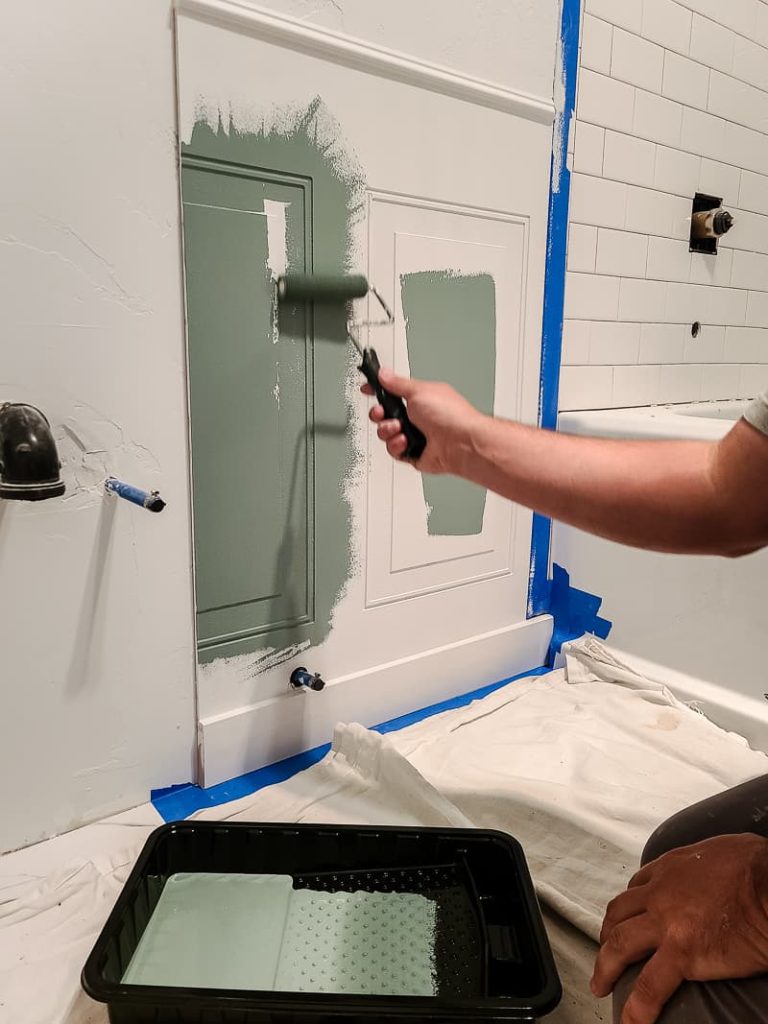 Painting wainscoting panel with paint roller.