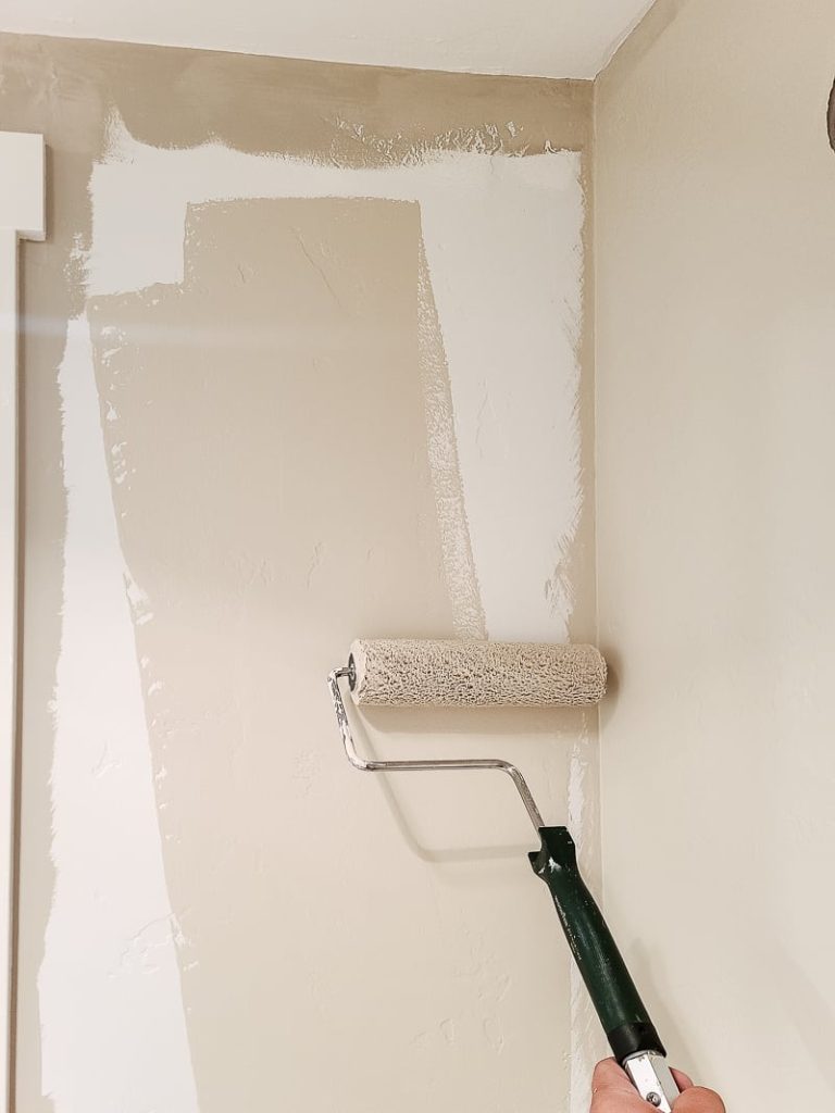 Looking for a Beige paint color? Here is Behr sculptor clay being rolled onto  walls in our bathroom with a paint roller