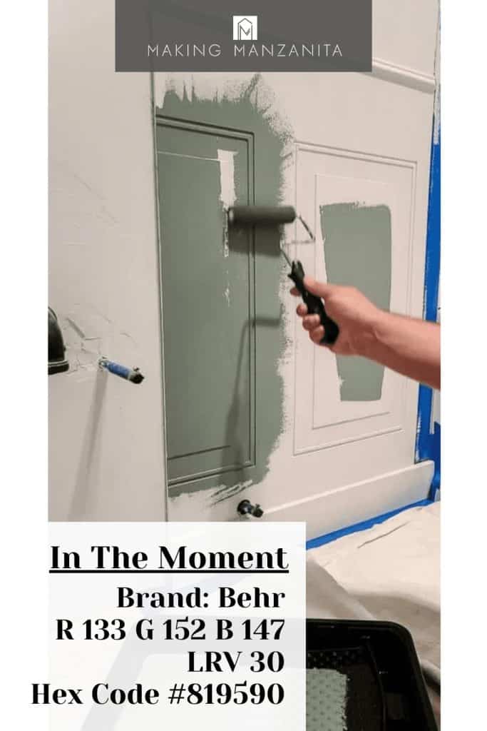 Roller painting wainscoting panel with Behr Paint In The Moment blue green paint color with text overlay that has the paint color stats