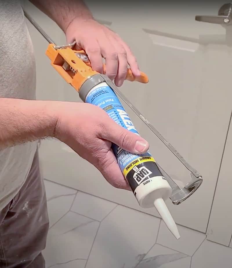 To load the caulking gun, put the bottom of the caulking tube in first, then the top. Push the trigger of the caulking gun so the barrel of the gun can tightly grip the tube.