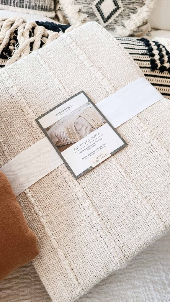 Closeup of Threshold brand cream color throw still in the packaging.