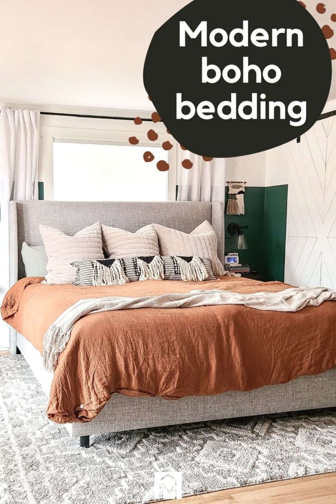 An image of king sized bed dressed with boho style bedding -- a large rust-colored duvet, a throw blanket, and accent pillows lined up against an upholstered gray headboard.