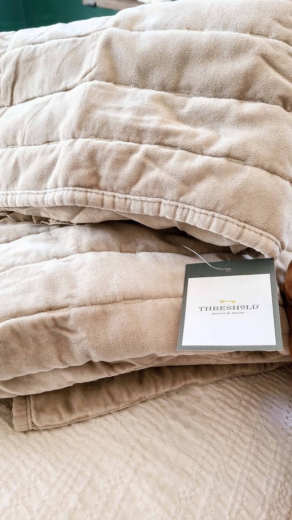 A closeup image of beige colored throw pillow covers. The velvet pillow covers are brand new, with the Threshold brand tag still attached.