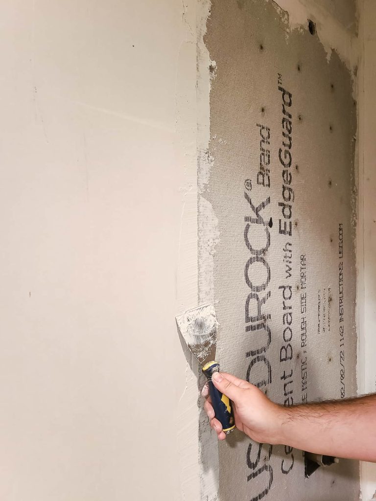 closeup applying mortar to cement board 