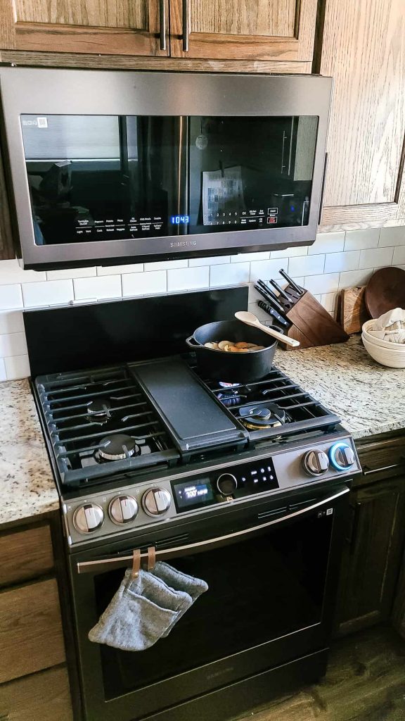I love that stovetop simmer pots for fall can be made using natural ingredients you usually have around your kitchen. This modern farmhouse kitchen with dark wood cabinets is simmering a stovetop potpourri that smells just like a fall harvest.