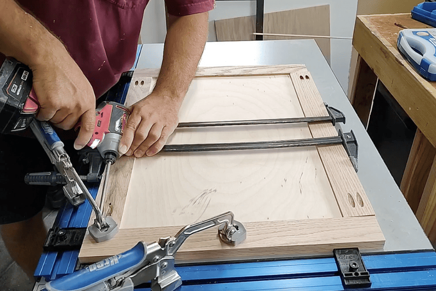 We used a clamp table to attach the wood pieces with pocket hole joinery on the door for the DIY trash can 