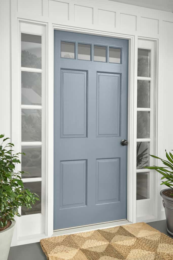 BEHR's adirondack blue is a pretty shade of grayish dusty blue that looks great painted on the front door of this house painted with white trim and exterior paneling