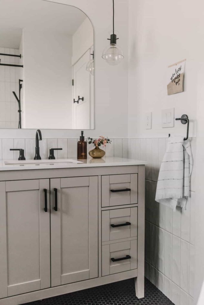 Behr Grey Mist is a beautiful soft greige paint color that works well with white and black accents for a modern look, like when painted on this bathroom vanity from Lemon Thistle. 