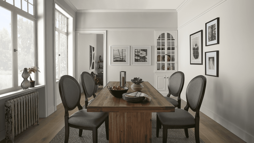 This contemporary dining room with natural light and a dark wall table looks great with the walls and trim painted with BEHR Mineral