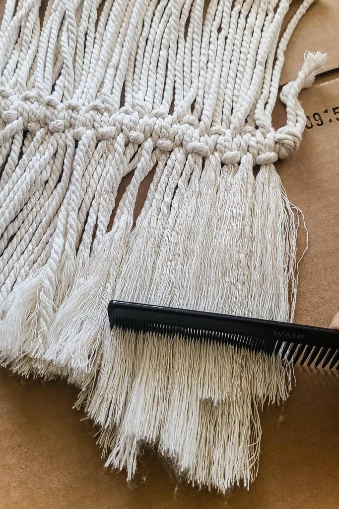 Using a comb to comb out the cord to make a macrame feather.