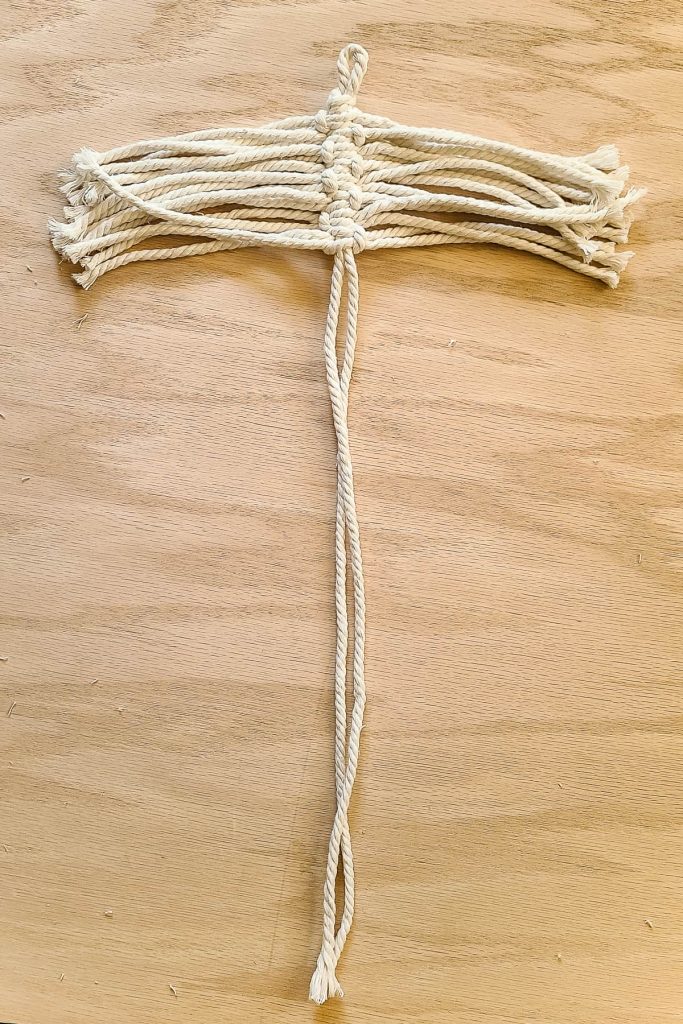 Process photo with square knots tied a third of the way down the center cord for the macrame feather