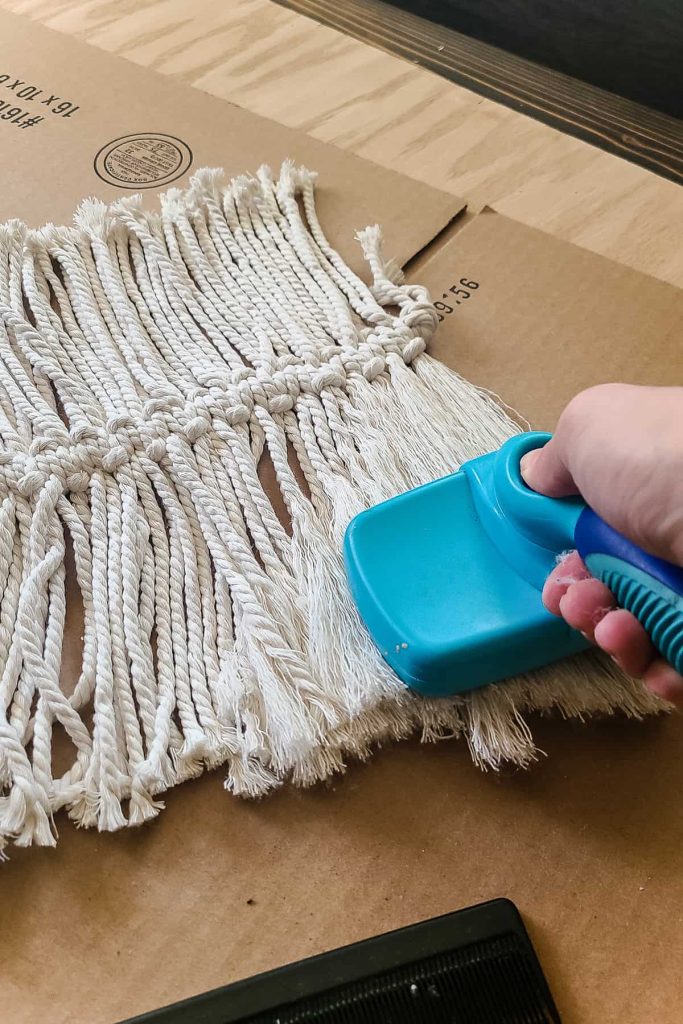 Using a pet hair brush to comb out the macrame cord.