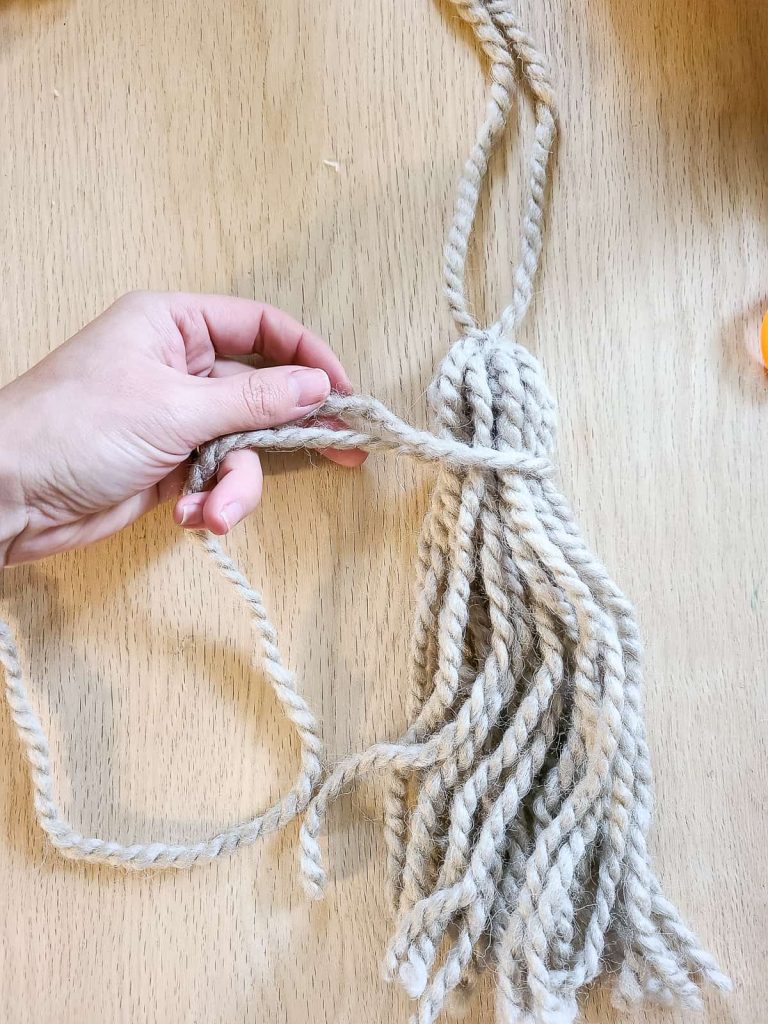 adding a decorative knot to the top of the tassel