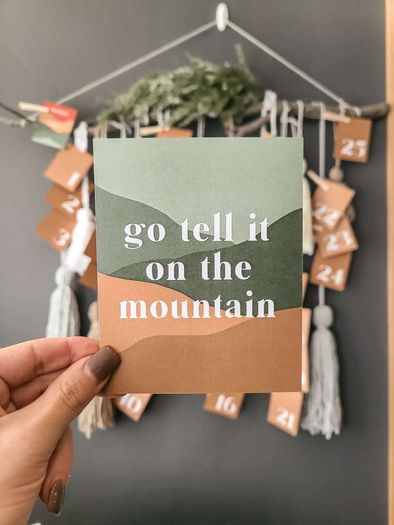 Boho style advent calendar cards with numbers on back to countdown until christmas. They are all beautifully designed, like this one that says go tell it on the mountain with abstract mountainscape